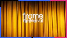 Guldfärgad ridå med Frame logo projicerad på.