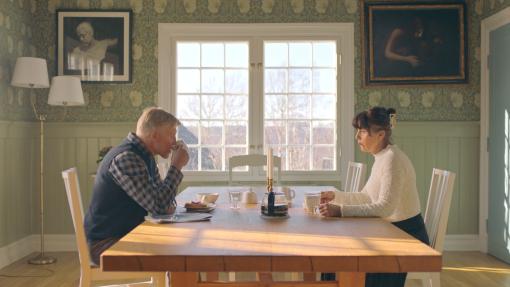 Man och kvinna dricker kaffe vid matsalsbord